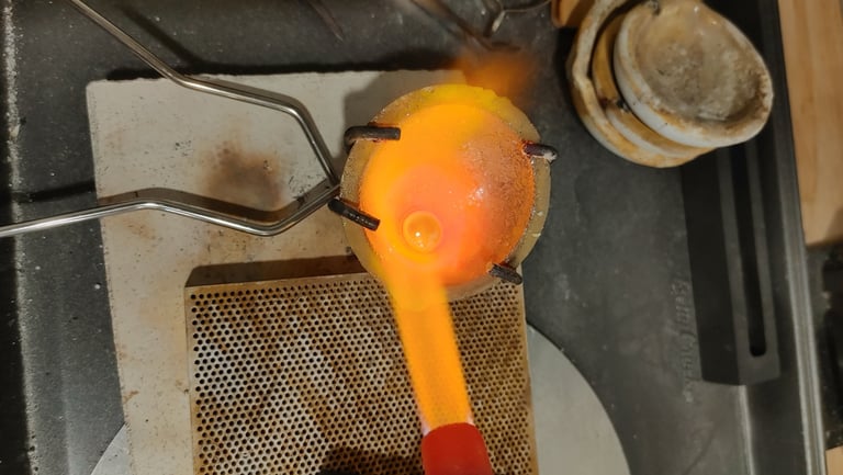 Molten sterling silver being heated and poured during the jewelry-making process.
