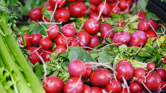 a lot of radishes with green leaves