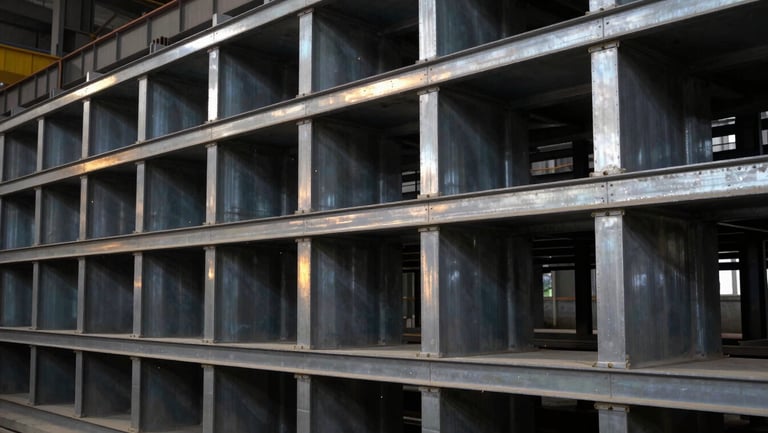 Heavy industrial steel structures neatly aligned inside a manufacturing facility, cool steel tones with high-contrast sharp focus.