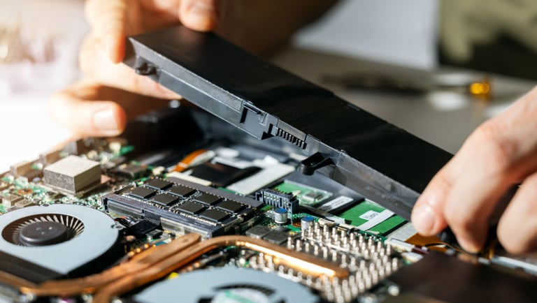 a person holding a piece of a laptop computer