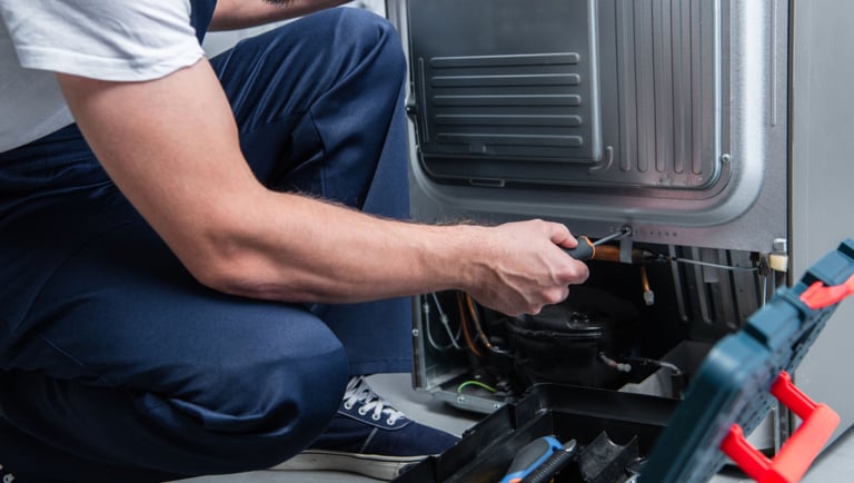 a man in a white shirt is fixing a machine