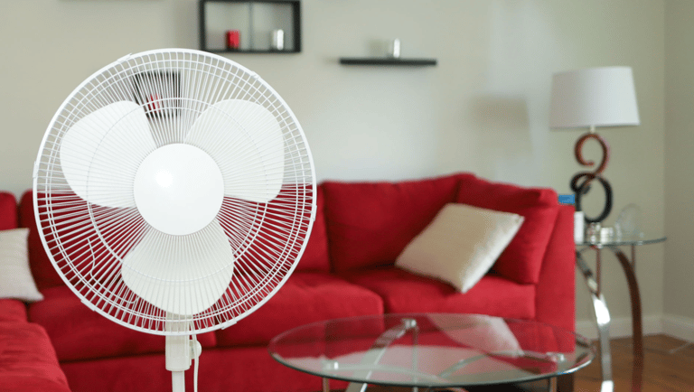 a red couch and a table with a fan