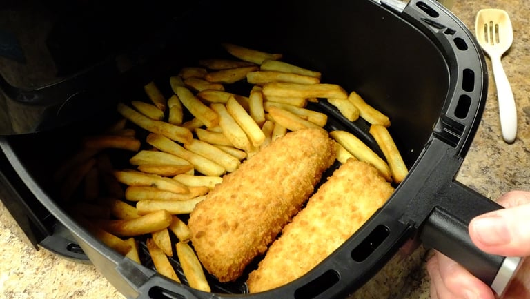 a person holding a fry fryer in a fryer