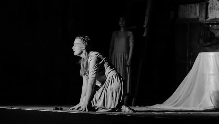 a woman in a long dress is kneeling on a stage