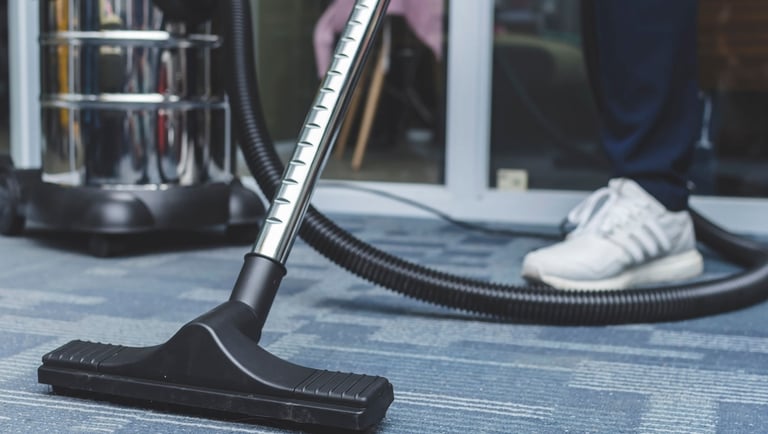 a person is cleaning a carpet with a vacuum
