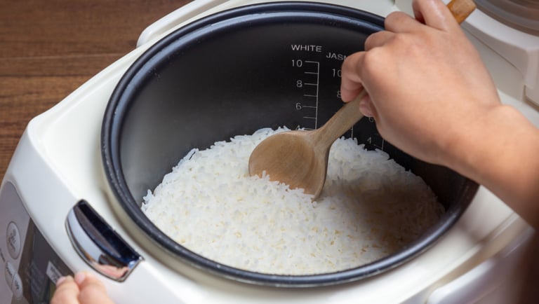 a person is cooking rice in a rice cooker