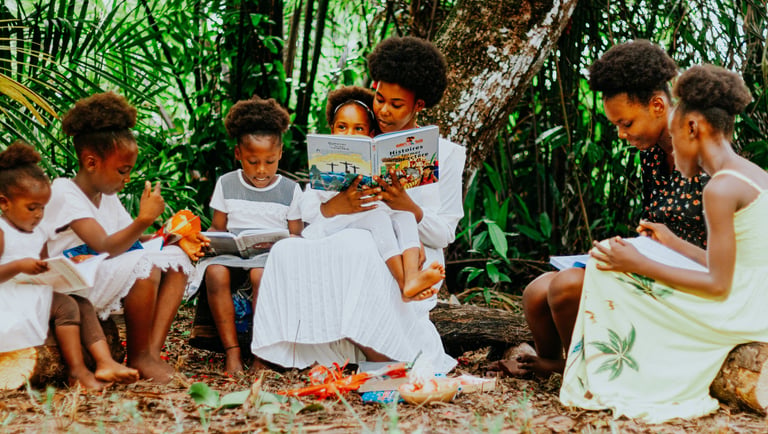 Jeunes femme assise avec les enfants sous un arbres