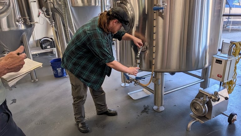 brewer pulling from a tap at compass rose brewing