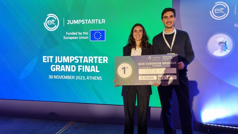 a man and woman standing next to a giant screen