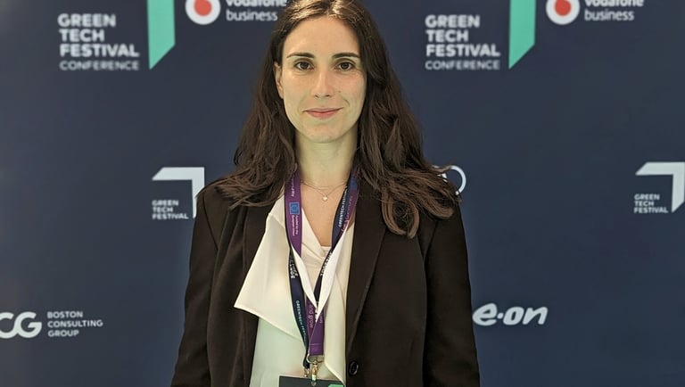 a woman in a suit and a name tag on a blue background