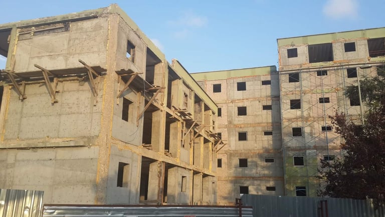 Bir yapının güçlendirme ve onarım aşamalarını gösteren fotoğraf.