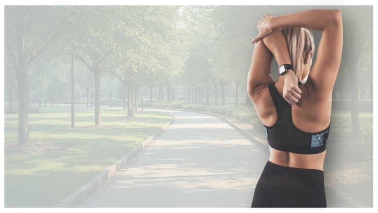 Woman in sports bra stretching her arms and back before a run in a sunny park.
