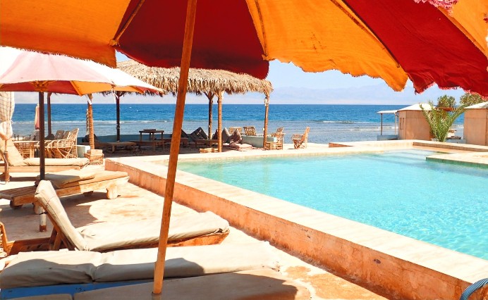Beach pool with lounge chairs and umbrellas