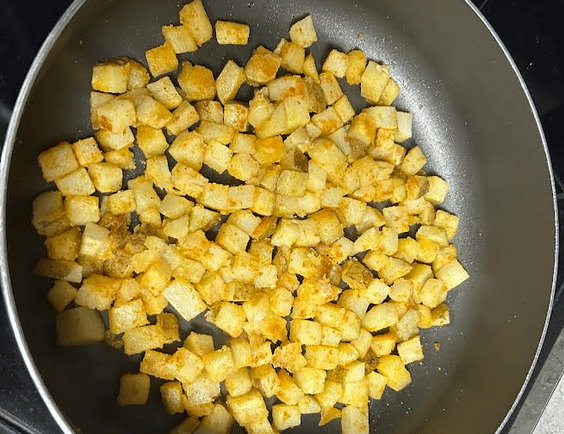 Breakfast Potatoes cooking in a pan on stove