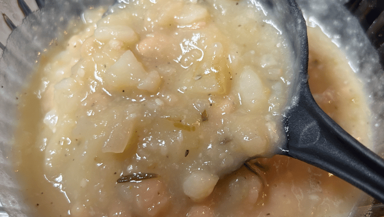 Potato Soup, when copleted, with large serving spoon starting to lift out of dish. For FlavorfulBites