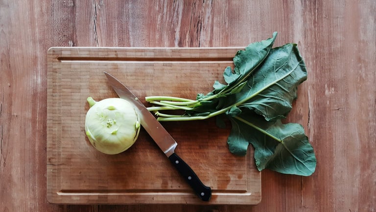 Cime di rapa fresche su tagliere di legno con coltello