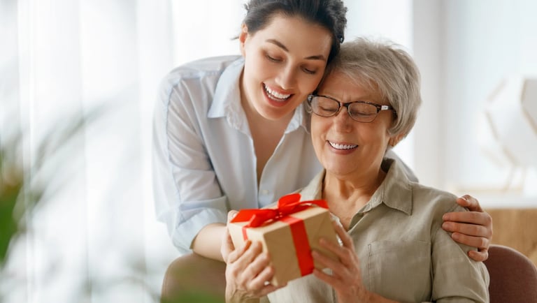 Una hija dándole un regalo personalizada a su mamá por el día de la madre.