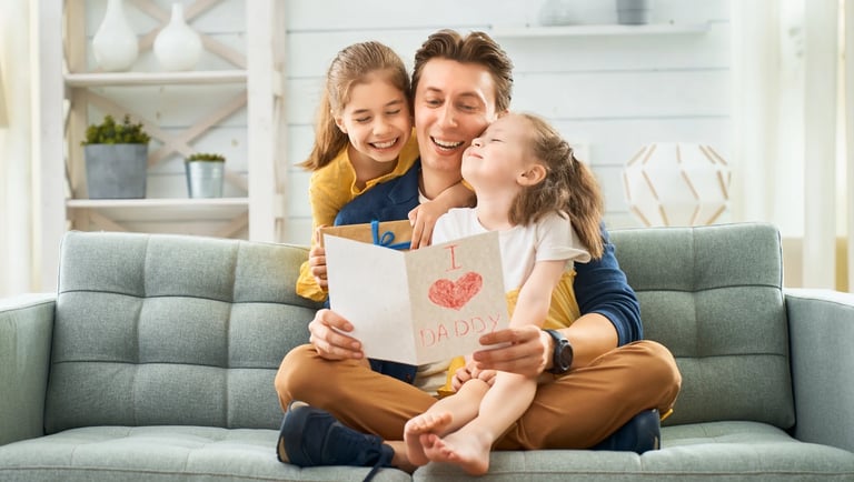 Hijas dándole un regalo personalizada a su papá por el día del padre.