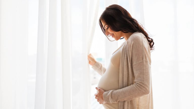 Mujer sonriendo y feliz de estar embarazada.