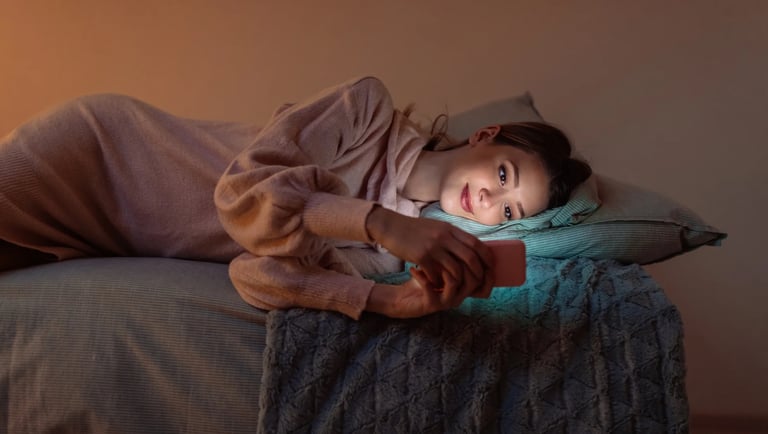 Novia leyendo un mensaje de buenas noches amoroso y bonito por Whatsapp antes de dormir.