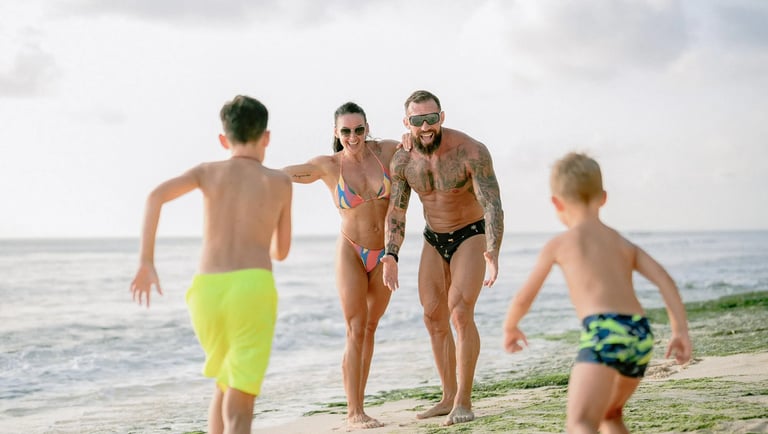 Children running toward their parents during a playful family photography session at Dreamland Beach Bali.