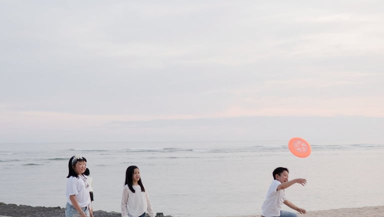 Children playing together on the beach during a relaxed family photography session at The Ritz-Carlton Bali Nusa Dua