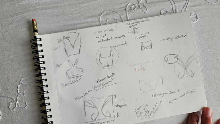 Hand-drawn pencil sketches and crochet pattern notes for a DIY top in a spiral notebook.