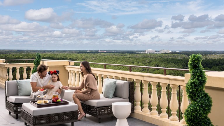 Family relaxing on the private terrace of the Royal Suite at Four Seasons Orlando with a view of Walt Disney World.