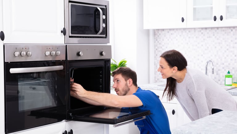 a man and woman are looking at a microwave