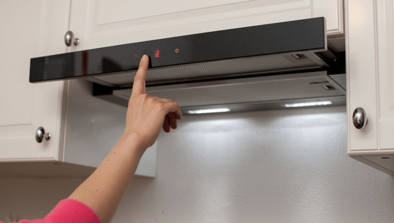 a person pointing at a microwave and oven