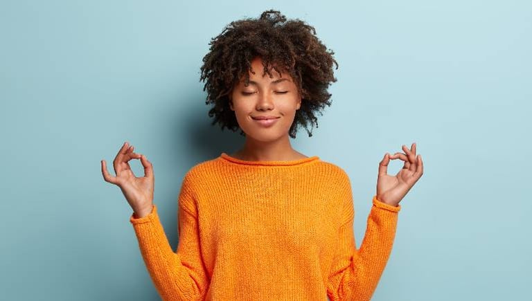 woman in orange jumper meditating