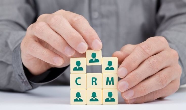 CRM concept with businessperson arranging cubes that represent customer relationship management strategy