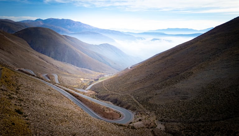 a winding road in the mountains with a view of the mountains