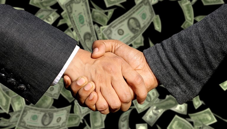 two people shaking hands with money bills and money