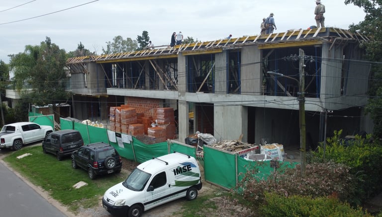 a group of people standing on a building with a truck parked in front of it