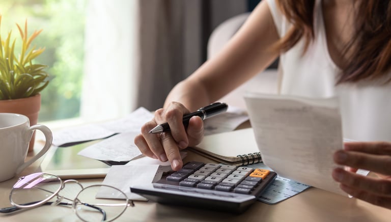 a woman is sitting at a desk with a calculator