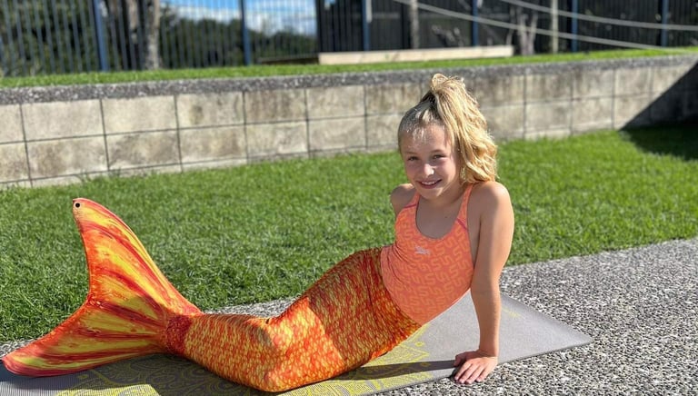 Child in a Mermaid tail learning to swim