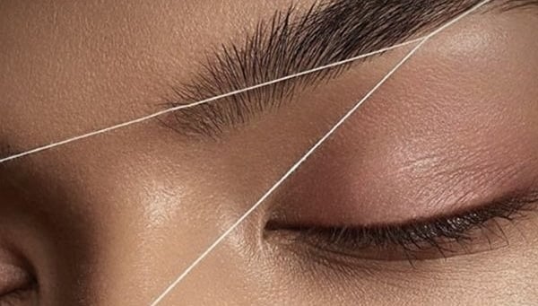 a woman with a WAXING WITH THREAD brow