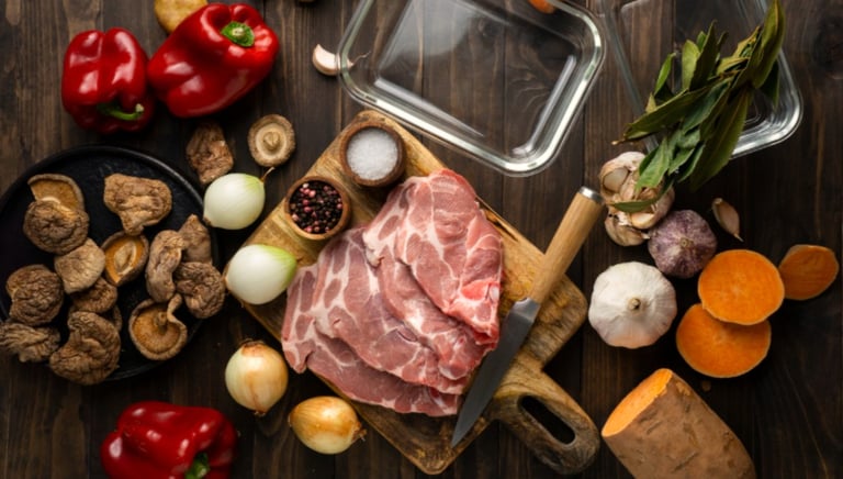 a variety of vegetables and meat on a wooden table
