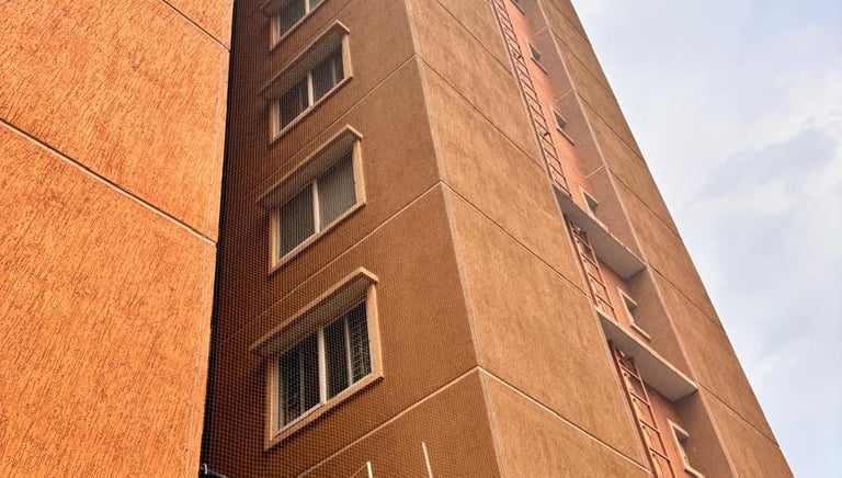 Close-up of a tightly installed protective pigeon net on a building duct.
