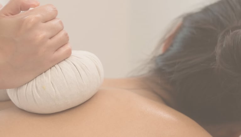 A massage therapist applies a warm Thai ball herbal compress at Zen Massage Therapy in Norfolk