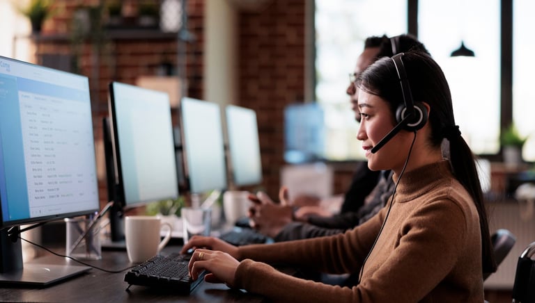 Call center agent using headset and computer in a modern customer support office