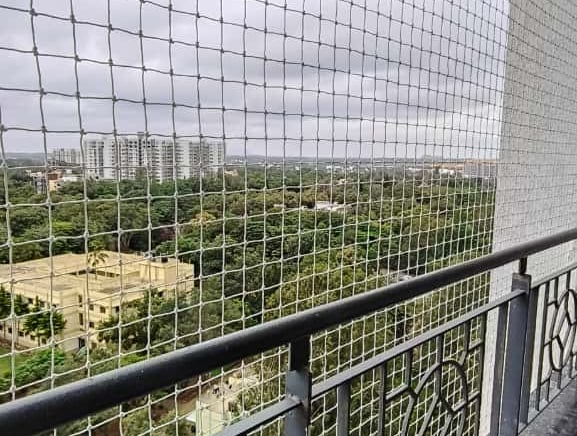 Technician installing a sturdy balcony safety net on a residential building in Thiruvanmiyur.