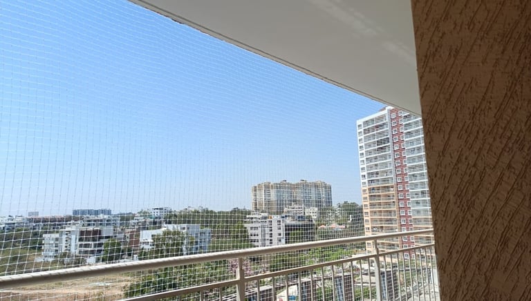 Close-up of a tightly woven pigeon net installed on a sunny balcony in Bengaluru