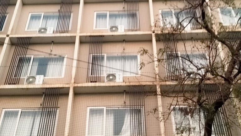Balcony covered with a neatly installed pigeon net to prevent bird entry.