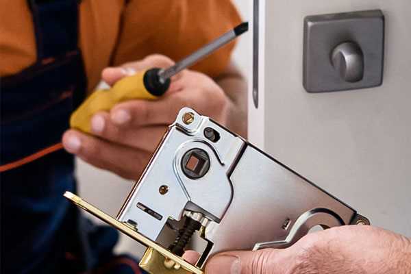 a man in a orange shirt is holding a screwdriver