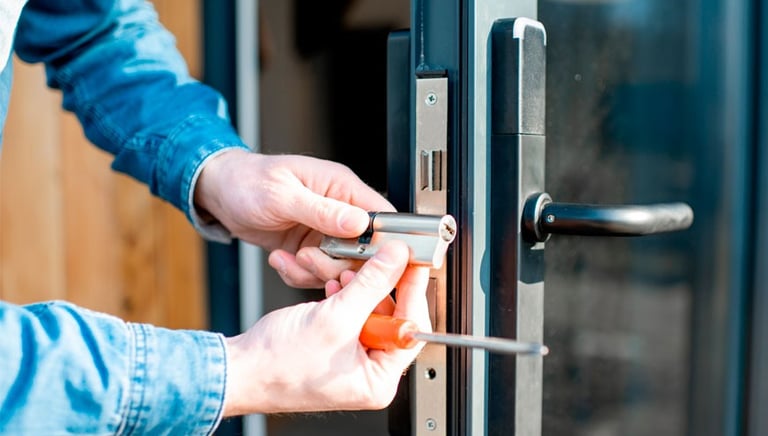 a person is holding a cell phone and looking at the door handle of a door