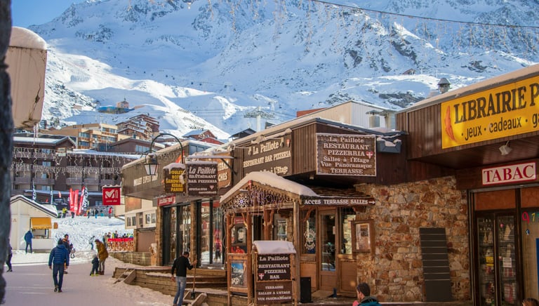 Winter village atmosphere in Val Thorens, French Alps, with snowy streets, mountain views, and alpine ski lifestyle.