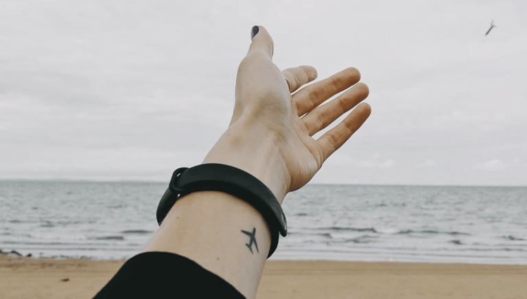A person reaches a hand toward the ocean beach,  a helping hand to folks looking for home care