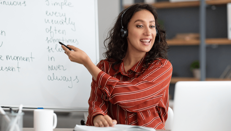 a woman in a red shirt is pointing at a white board